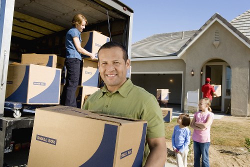 Professional movers handling furniture in a Hither Green street
